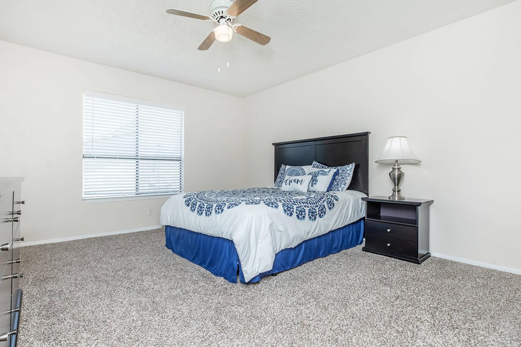 a bedroom with a bed and a ceiling fan