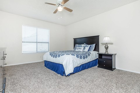 a bedroom with a bed and a ceiling fan