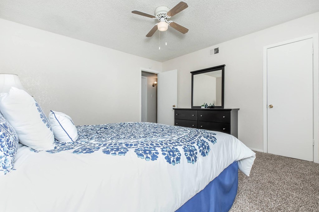 a bedroom with a large bed and a ceiling fan