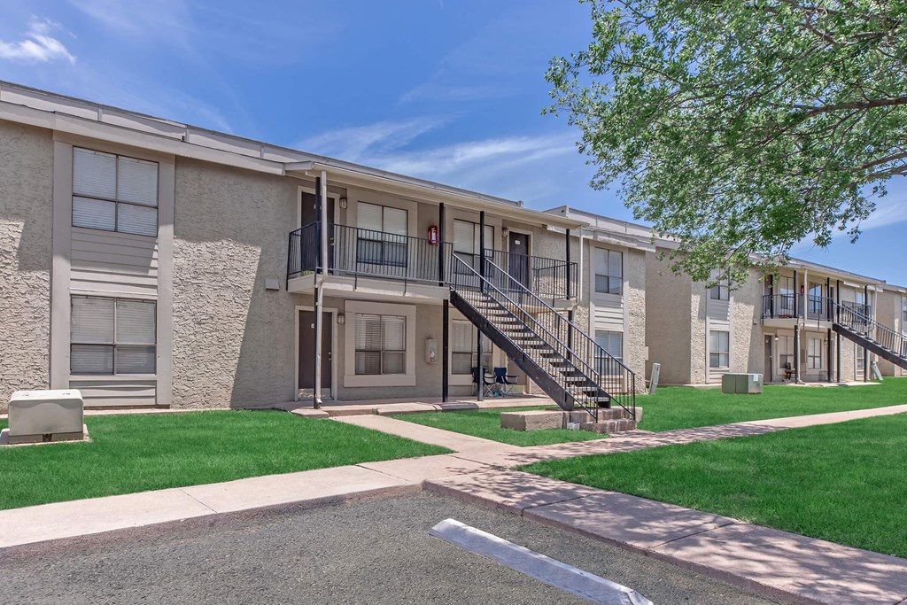 Apartment building with a tree in front.