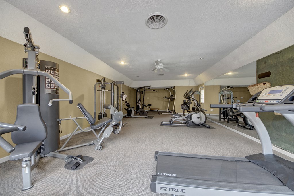 a gym with weights and cardio equipment in a home for sale