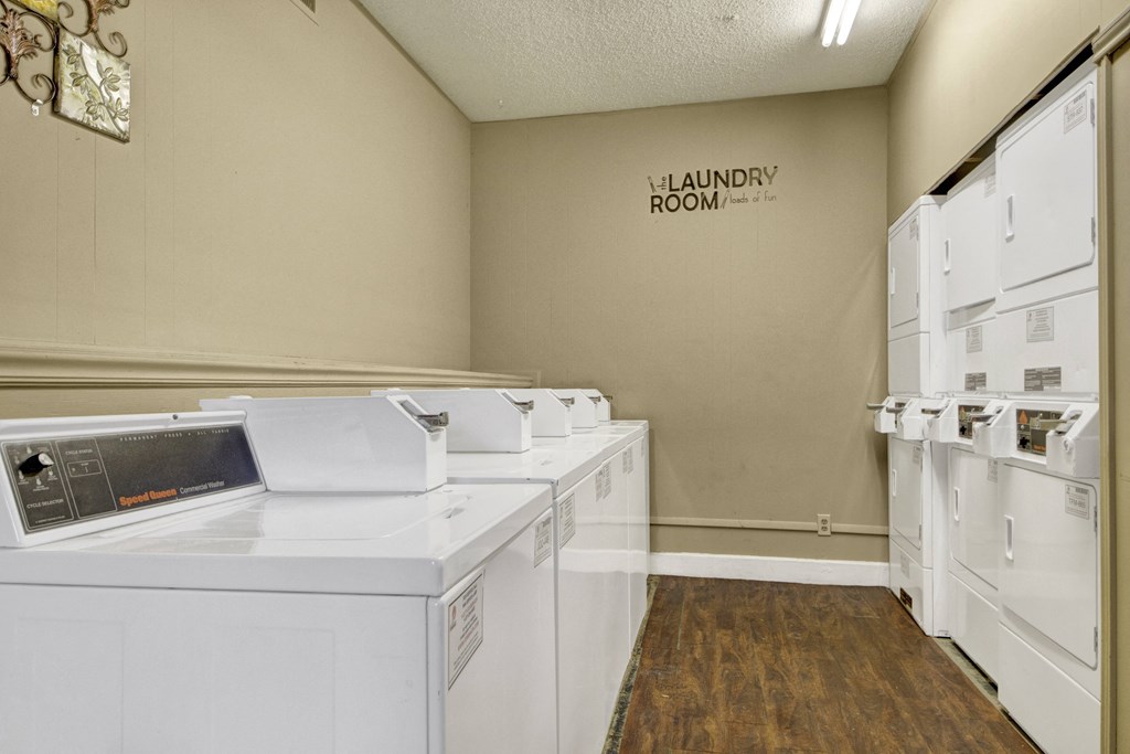 a laundry room with washers and dryers and a sign on the wall