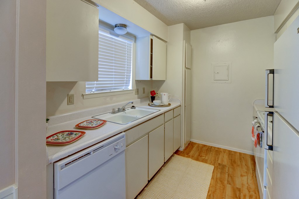 a kitchen with white cabinets and a sink and a refrigerator