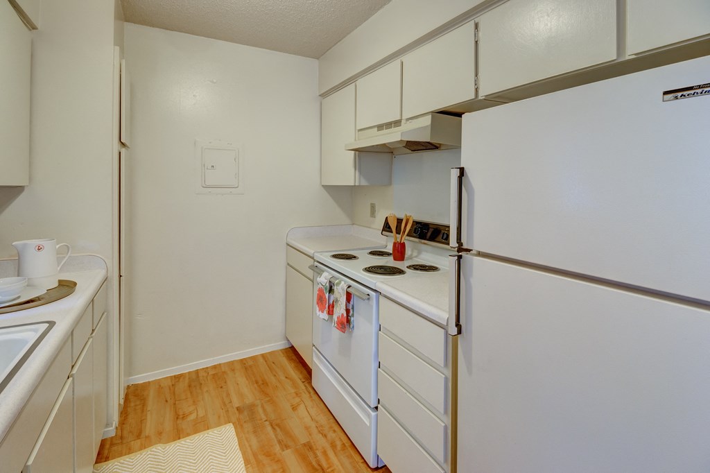 a kitchen with white appliances and a refrigerator