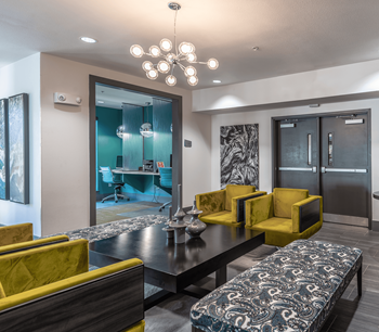 a living room with yellow couches and chairs and a table