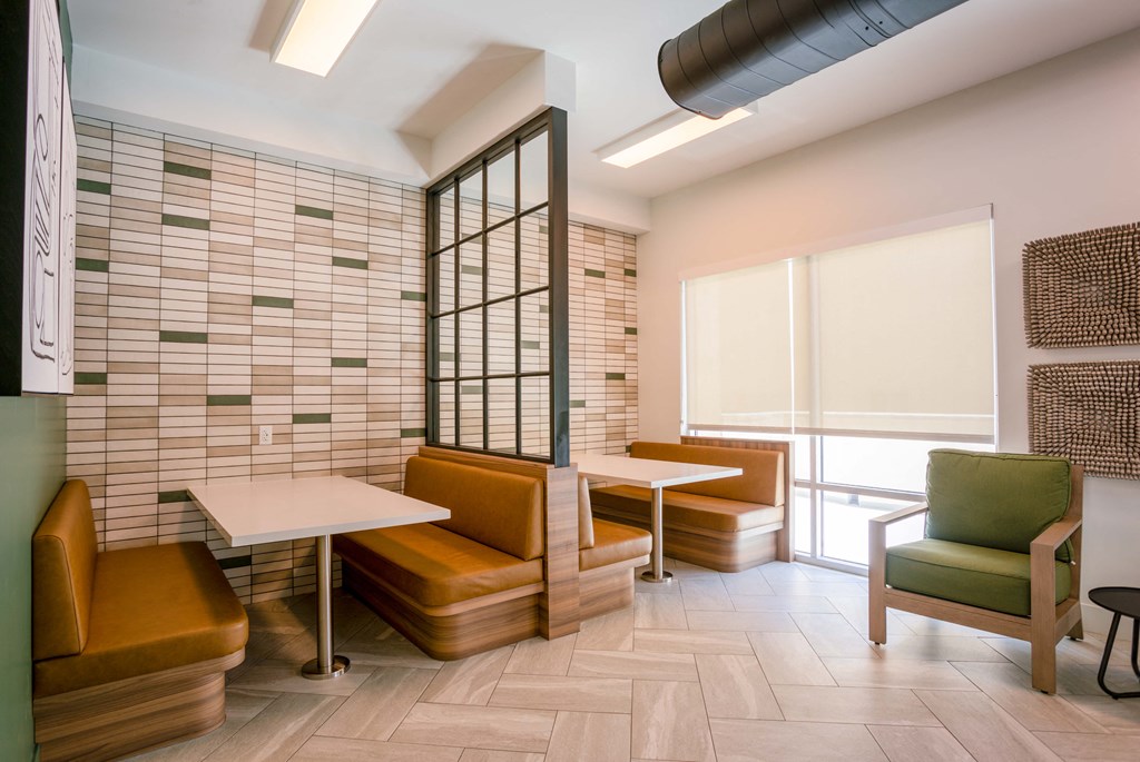 a seating area in a room with tables and chairs