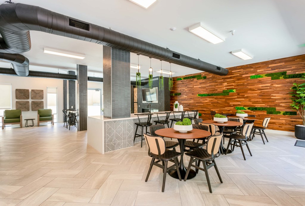 a dining room with tables and chairs and a moss wall