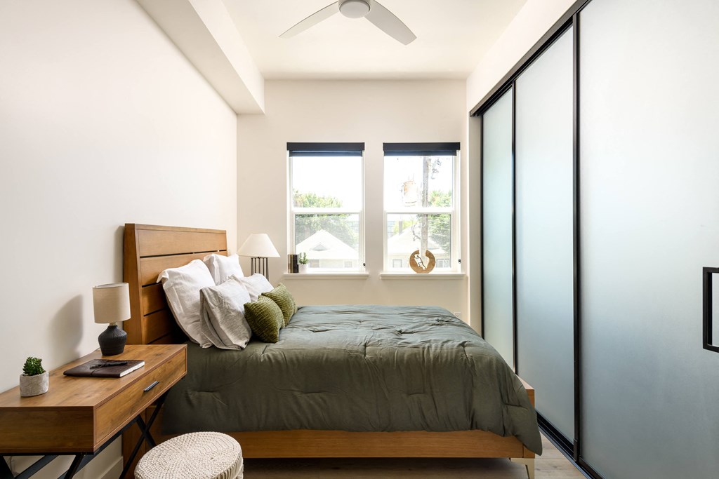 a bedroom with a bed and two windows