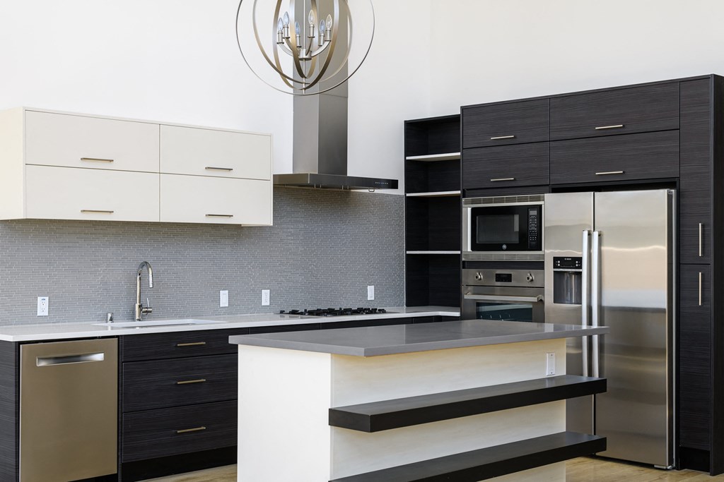 a modern kitchen with black and white counter tops and stainless steel appliances