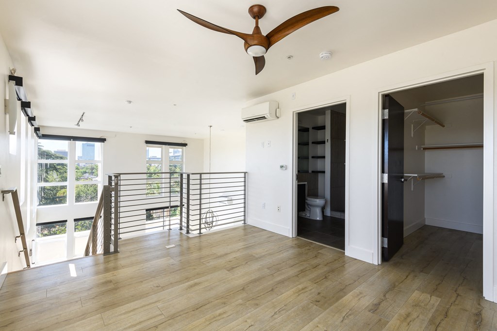 a living room with a staircase and a ceiling fan