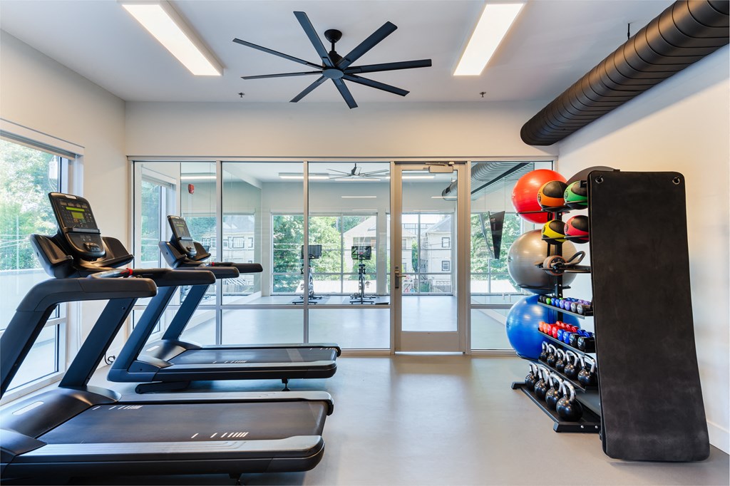 a gym with treadmills and other exercise equipment and glass doors