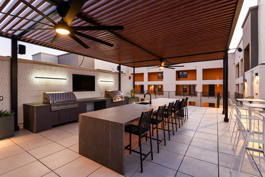 a large rooftop kitchen with a long bar and chairs