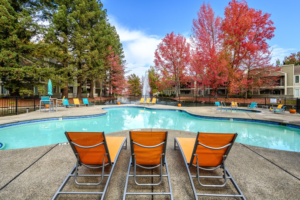 a swimming pool with orange chairs next to it