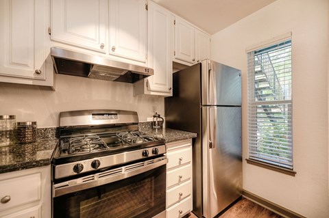 a kitchen with stainless steel appliances and white cabinets