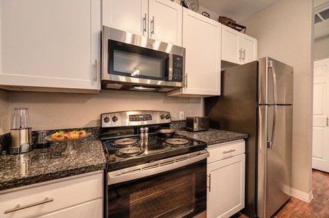 a kitchen with stainless steel appliances and white cabinets