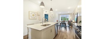 A modern kitchen with a large island and pendant lights.