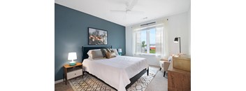 A bedroom with a large bed and a ceiling fan.