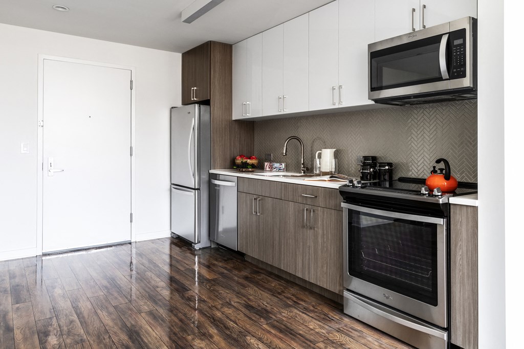a modern kitchen with stainless steel appliances and white cabinets