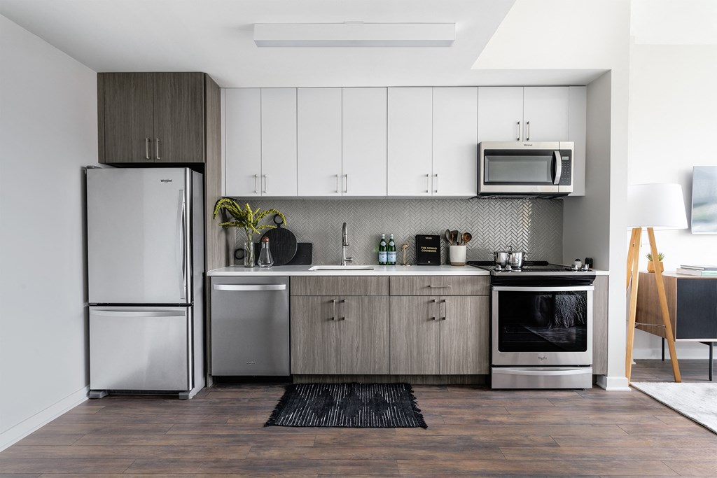 a small kitchen with white cabinets and stainless steel appliances