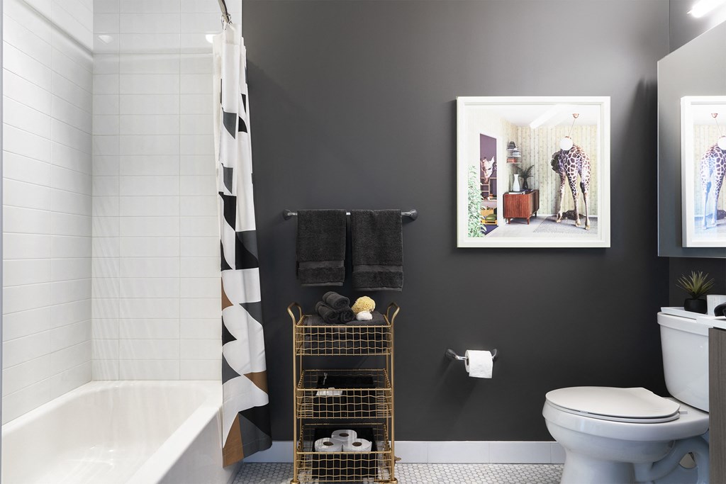 a bathroom with a toilet and a shower and a painting on the wall