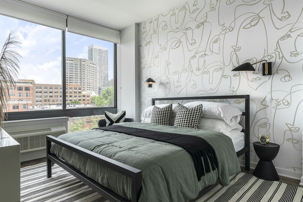 a bedroom with a bed and a large window