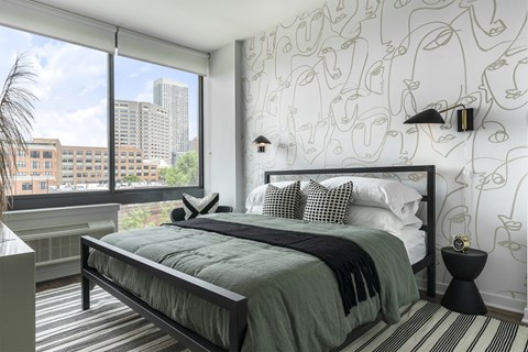 a bedroom with a bed and a large window