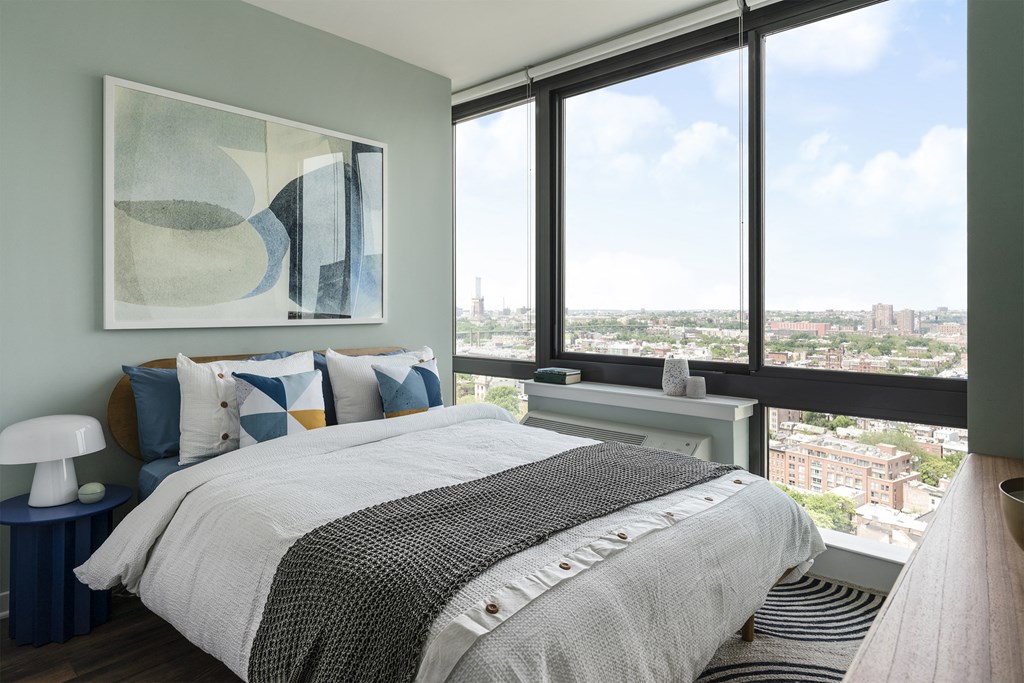 a bedroom with a bed and a view of the city