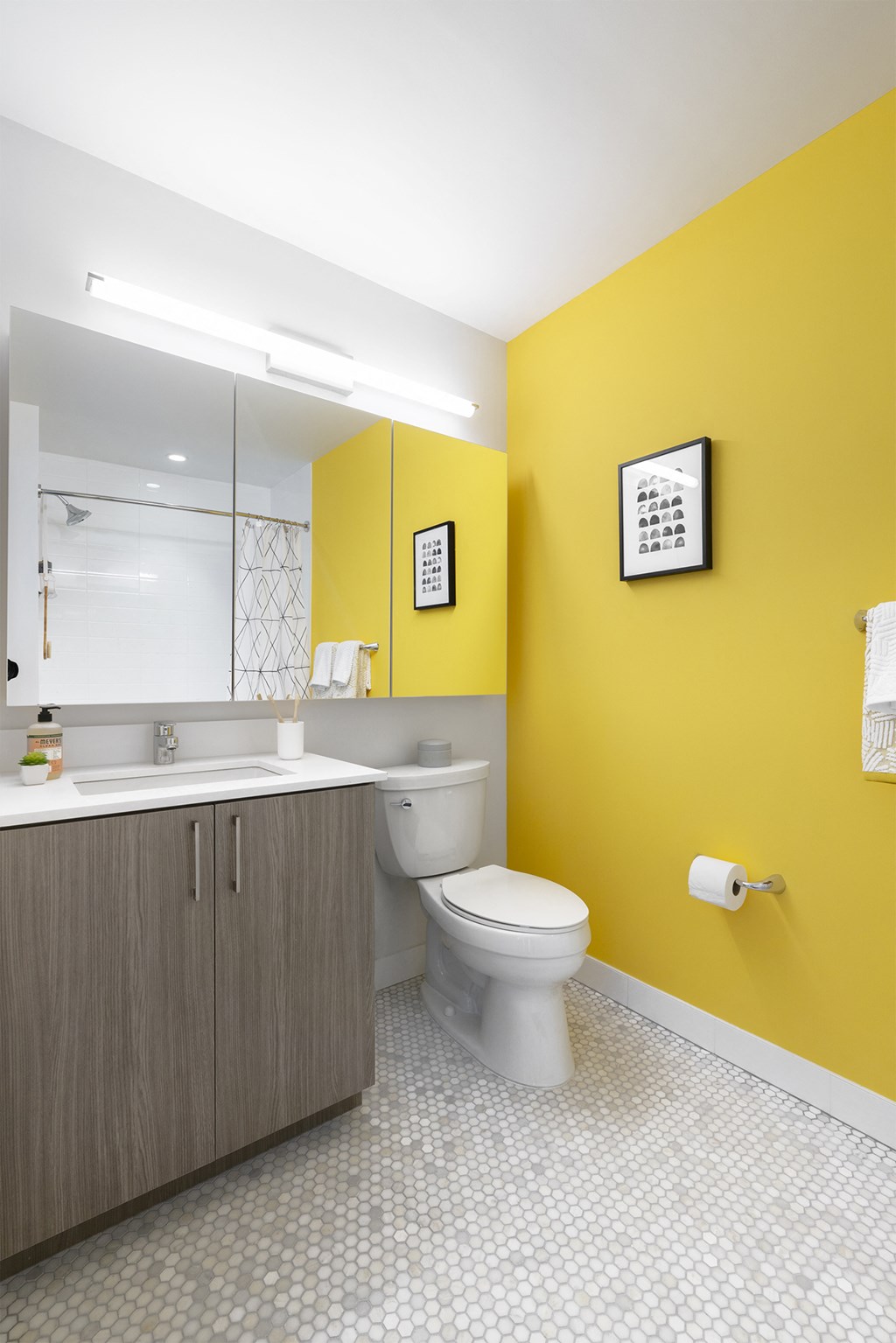a bathroom with a yellow wall and a white toilet