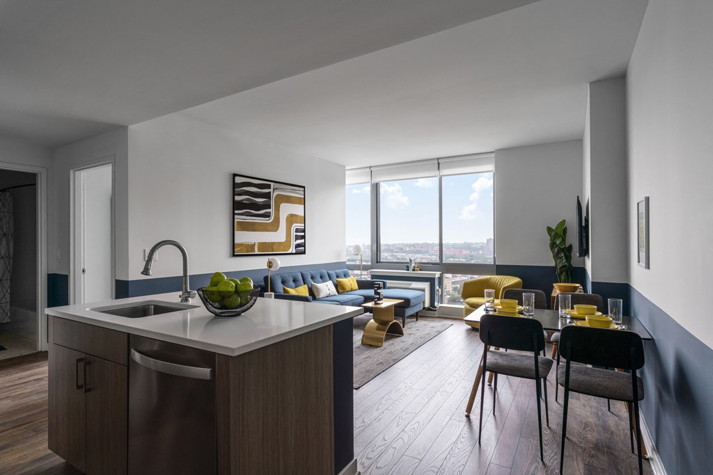 a living room with a kitchen and a large window