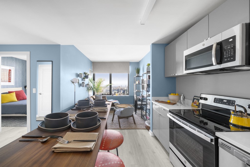 a kitchen and living room with a table and chairs and a microwave