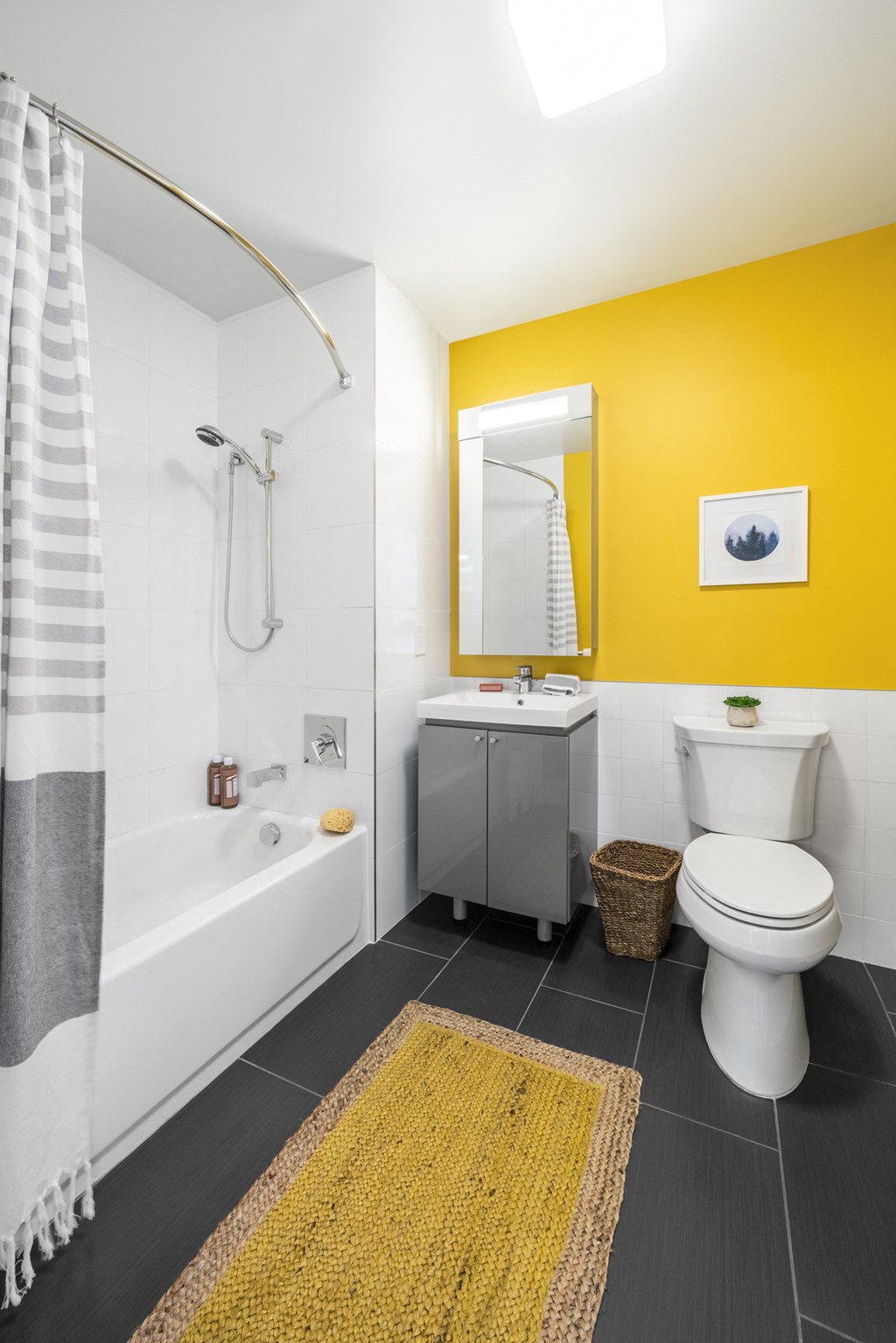 a bathroom with a yellow wall and a toilet and a tub