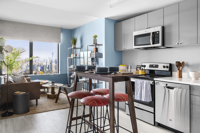 a kitchen and living room with a table and stools