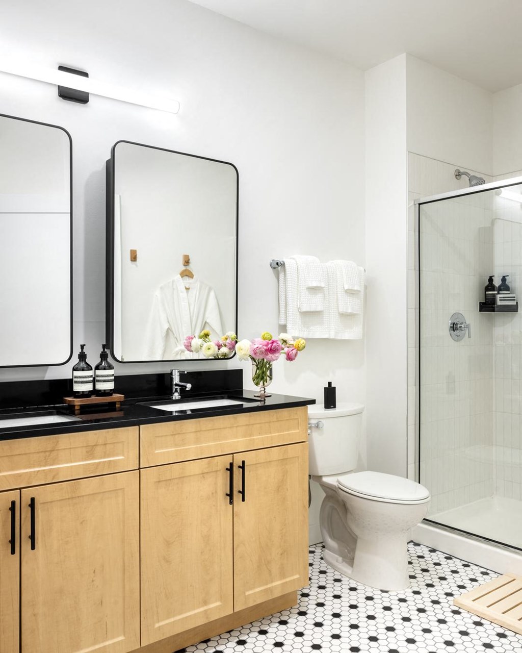 a bathroom with a toilet and two mirrors