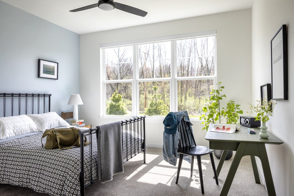 a bedroom with a bed and a large window