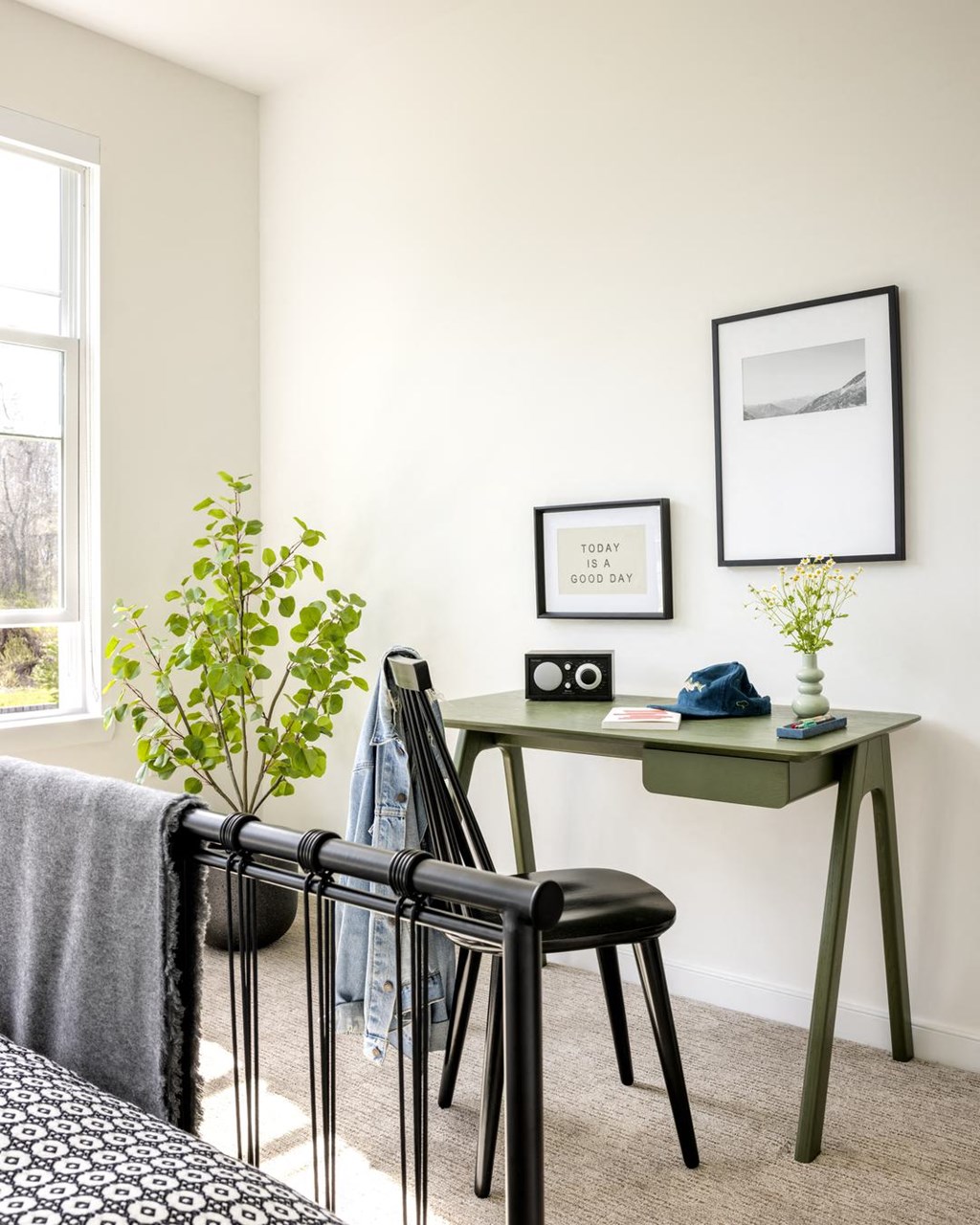 a green desk with a black chair in a bedroom