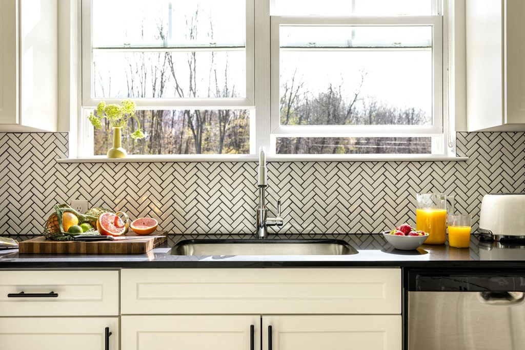 a kitchen with a sink and three windows
