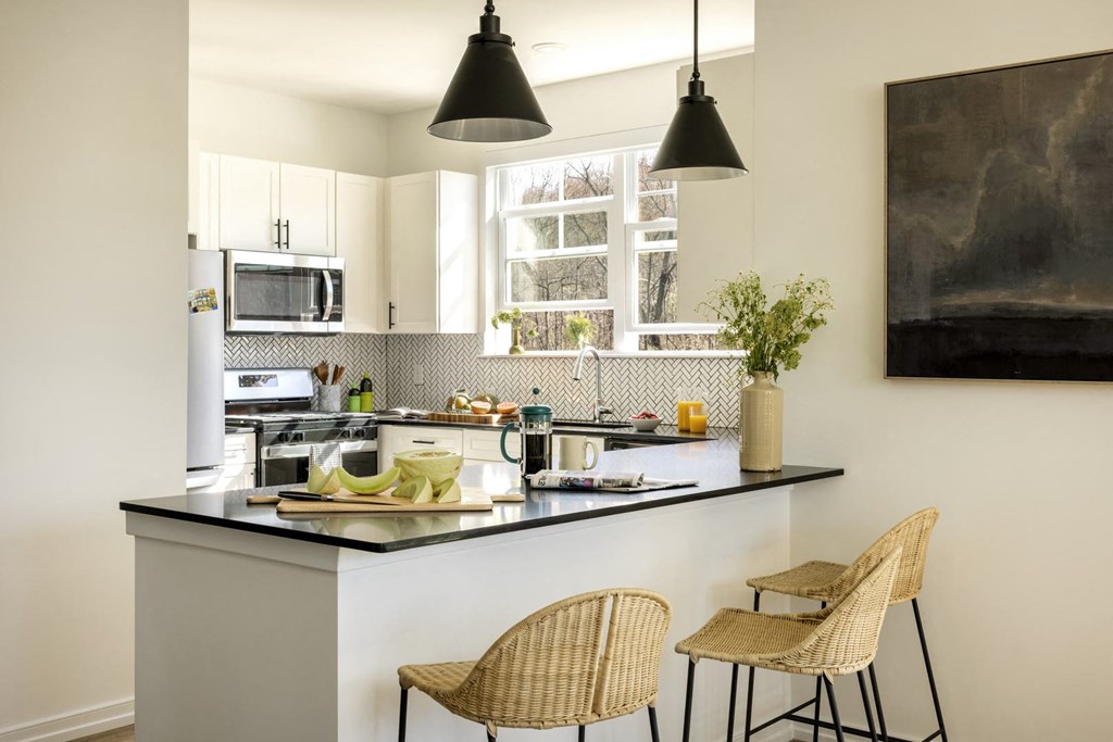 a kitchen with a counter and three stools