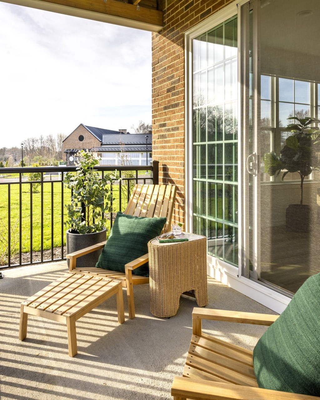 a balcony with wooden furniture and glass doors
