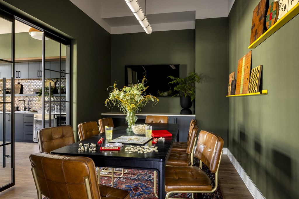 a dining room with leather chairs and a table with a vase of flowers