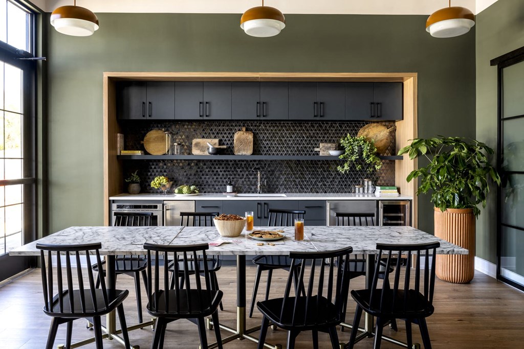 a kitchen with a marble table and black chairs