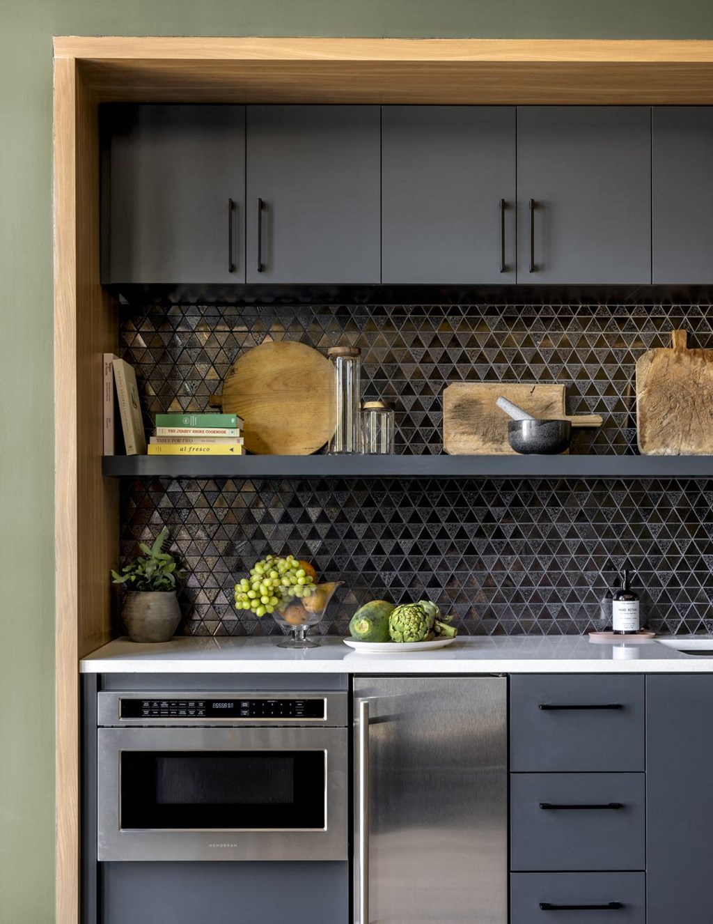 a kitchen with gray cabinets and a stainless steel oven and sink