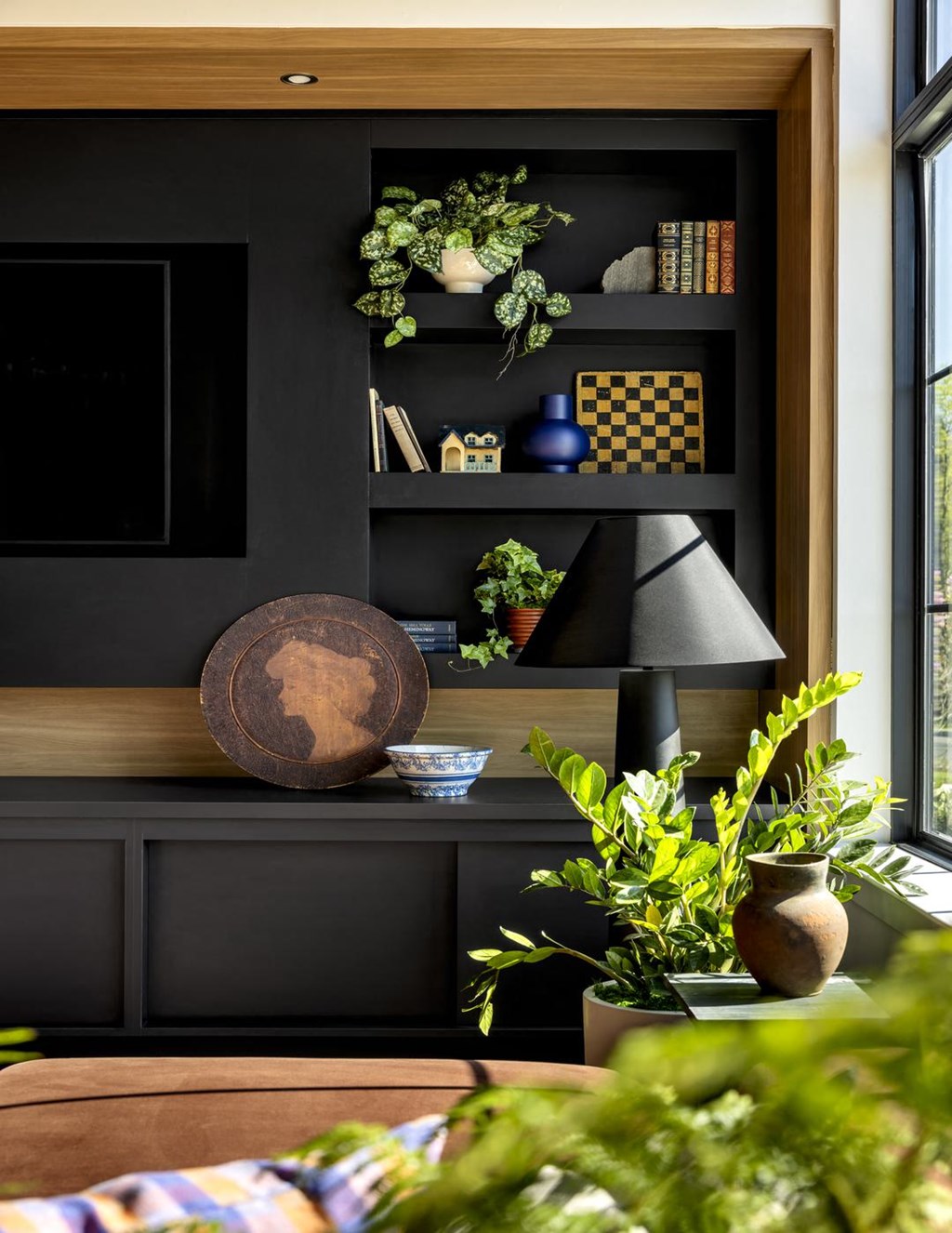 a living room with a black wall and a table with plants