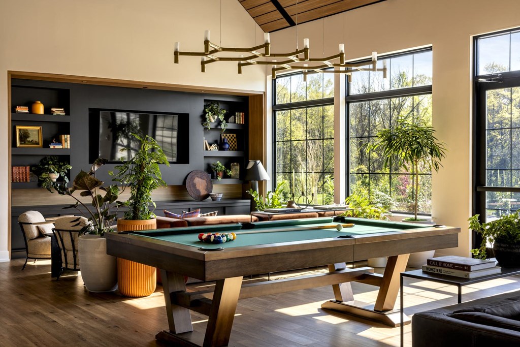 a pool table in a living room with large windows