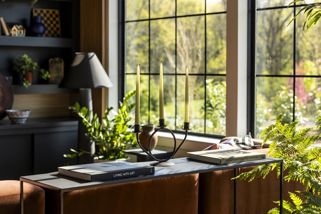 a living room with a table with books and a window