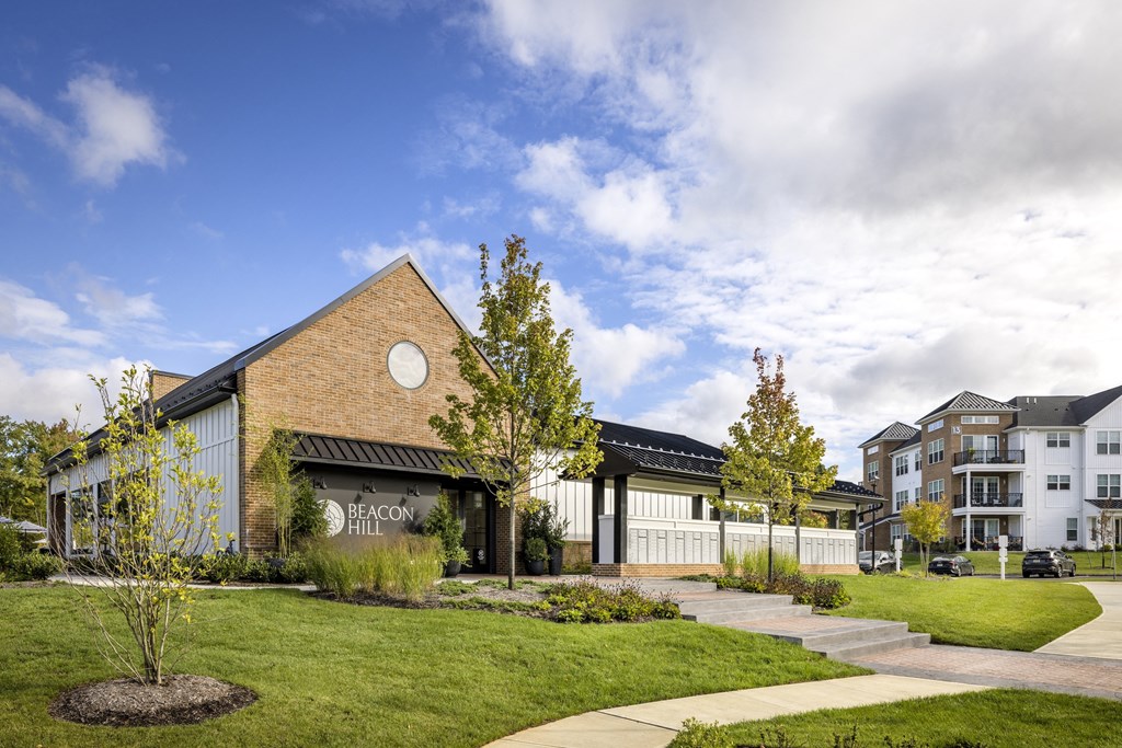 A building with a sign that says "Beacon Hill" is surrounded by a grassy area and trees.