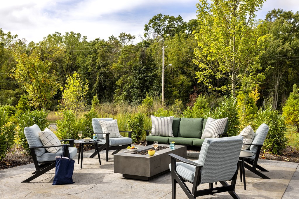 A set of outdoor furniture is arranged on a stone patio.