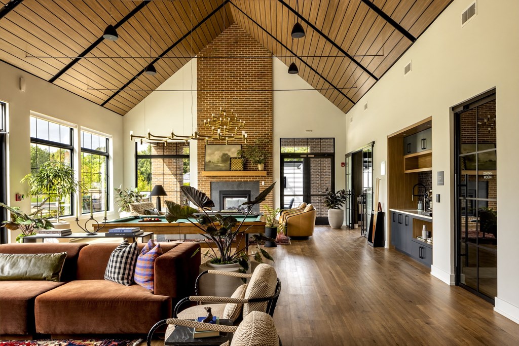 A living room with a brown couch and a wooden ceiling.