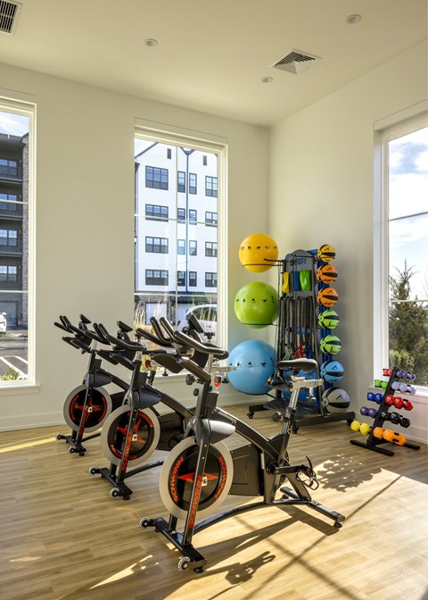 A home gym with exercise equipment and a window overlooking a city.