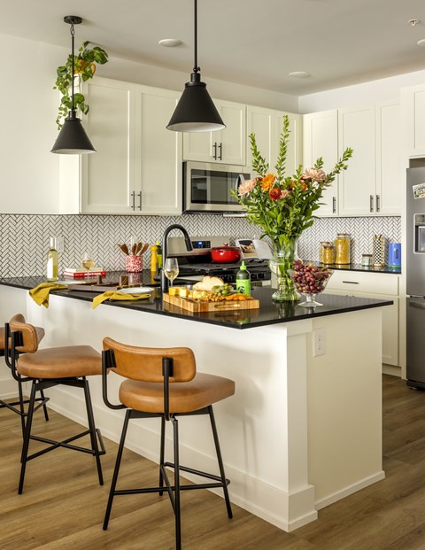 A kitchen with a black countertop and white cabinets.
