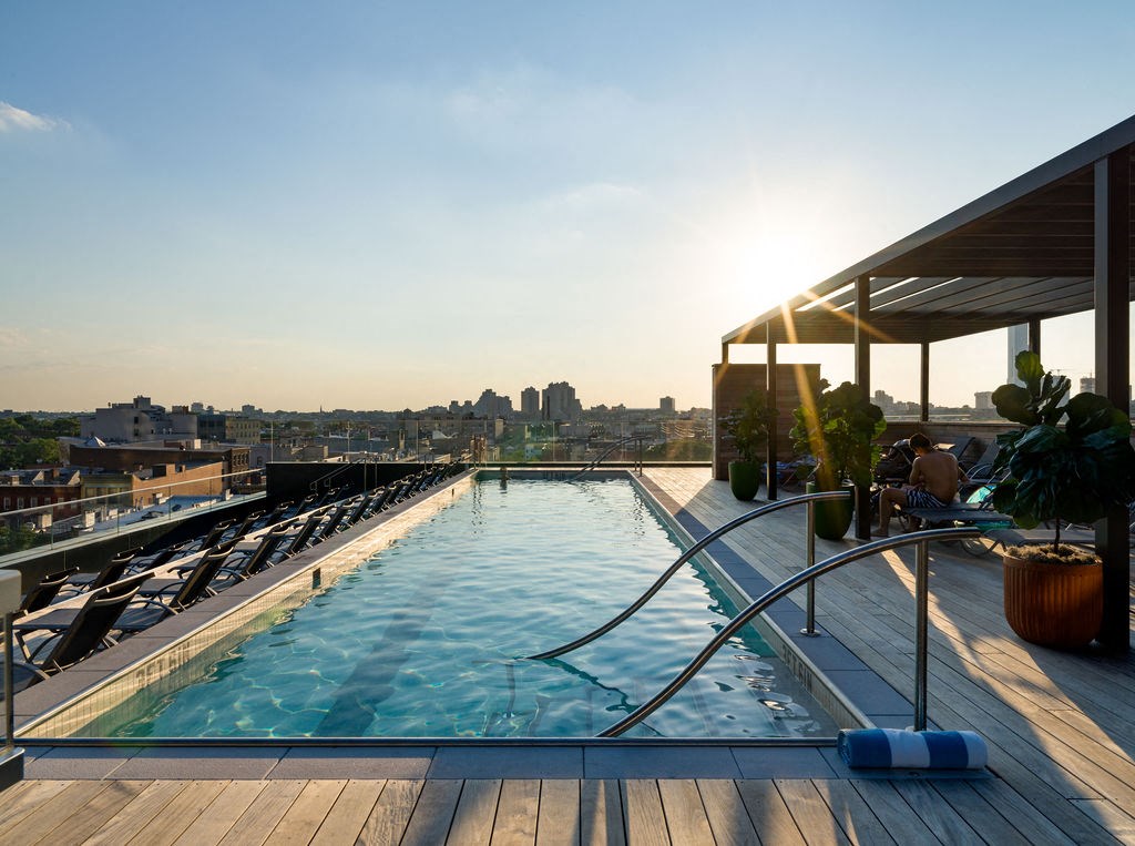 the pool on the roof of the hotel with a view of the city